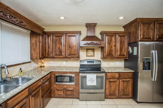 a kitchen with stainless steel appliances granite countertop a stove a sink and a refrigerator