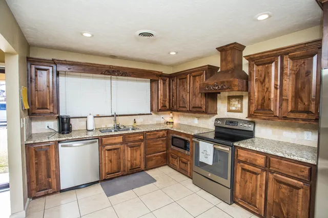 a kitchen with stainless steel appliances granite countertop a sink and stove top oven