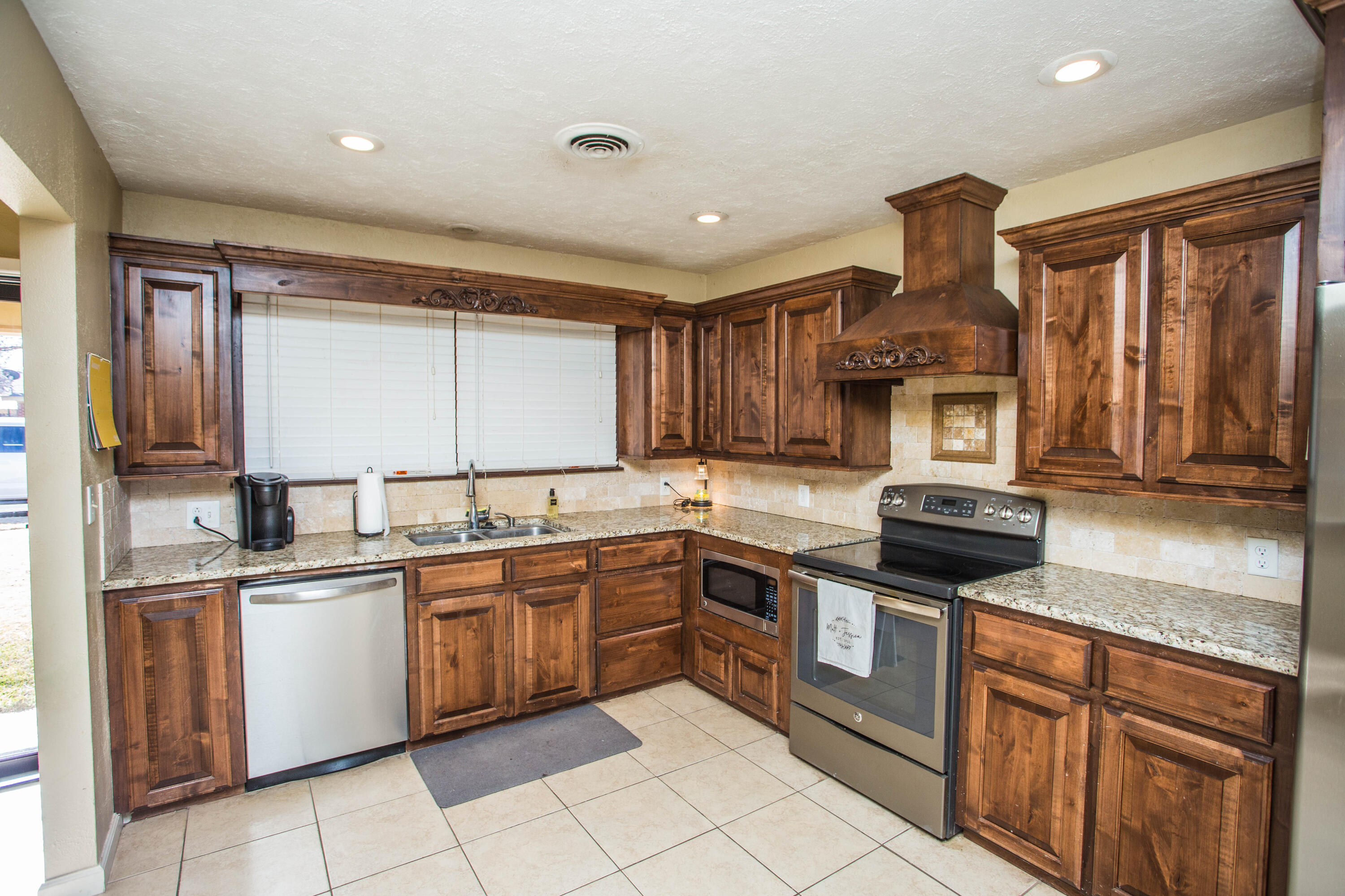 1550 West Lynn Street Slaton, TX 79364 - Photo 14 of 54 a kitchen with stainless steel appliances granite countertop a sink and stove top oven