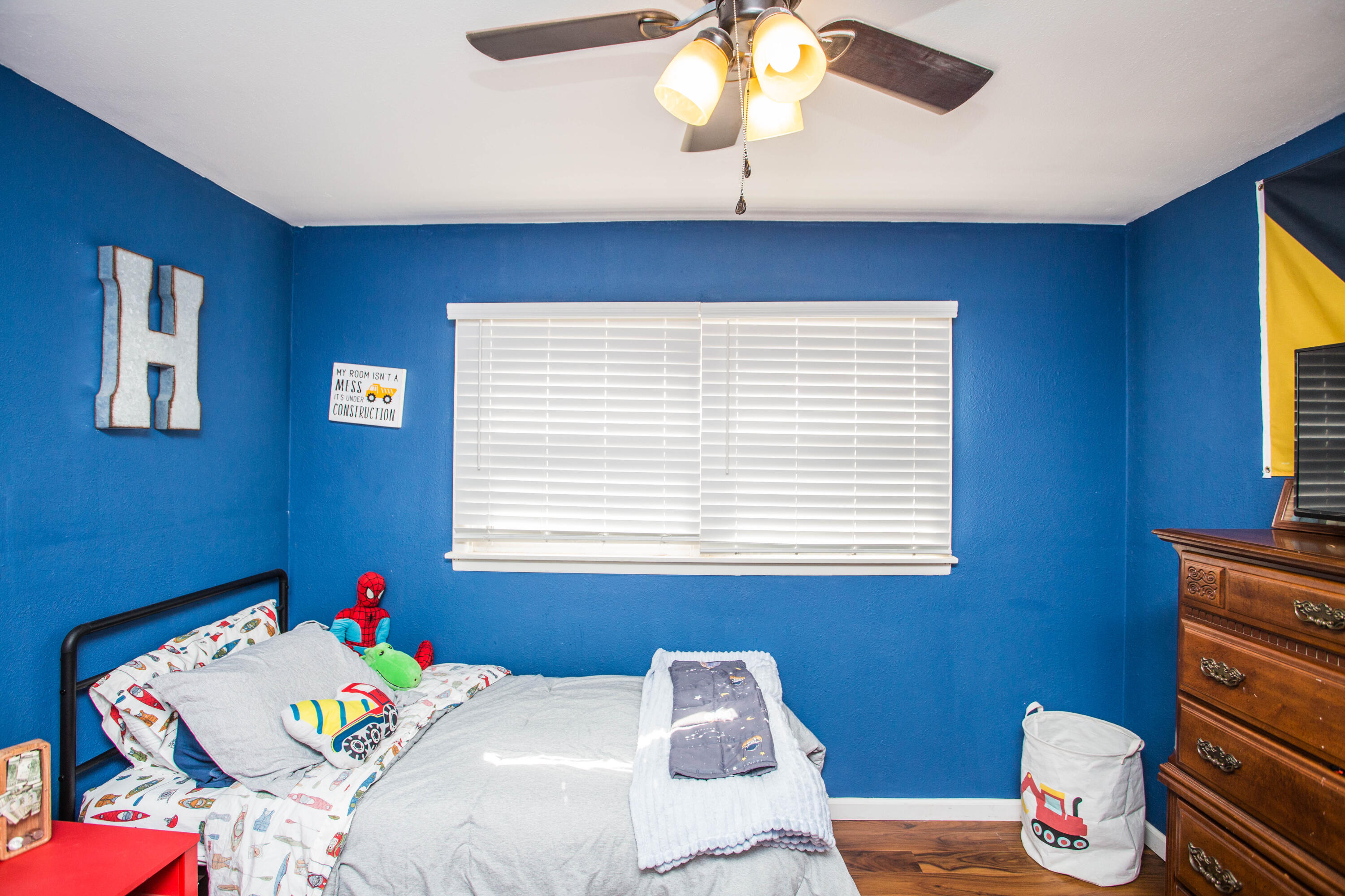 1550 West Lynn Street Slaton, TX 79364 - Photo 33 of 54 a bedroom with a bed and a chandelier