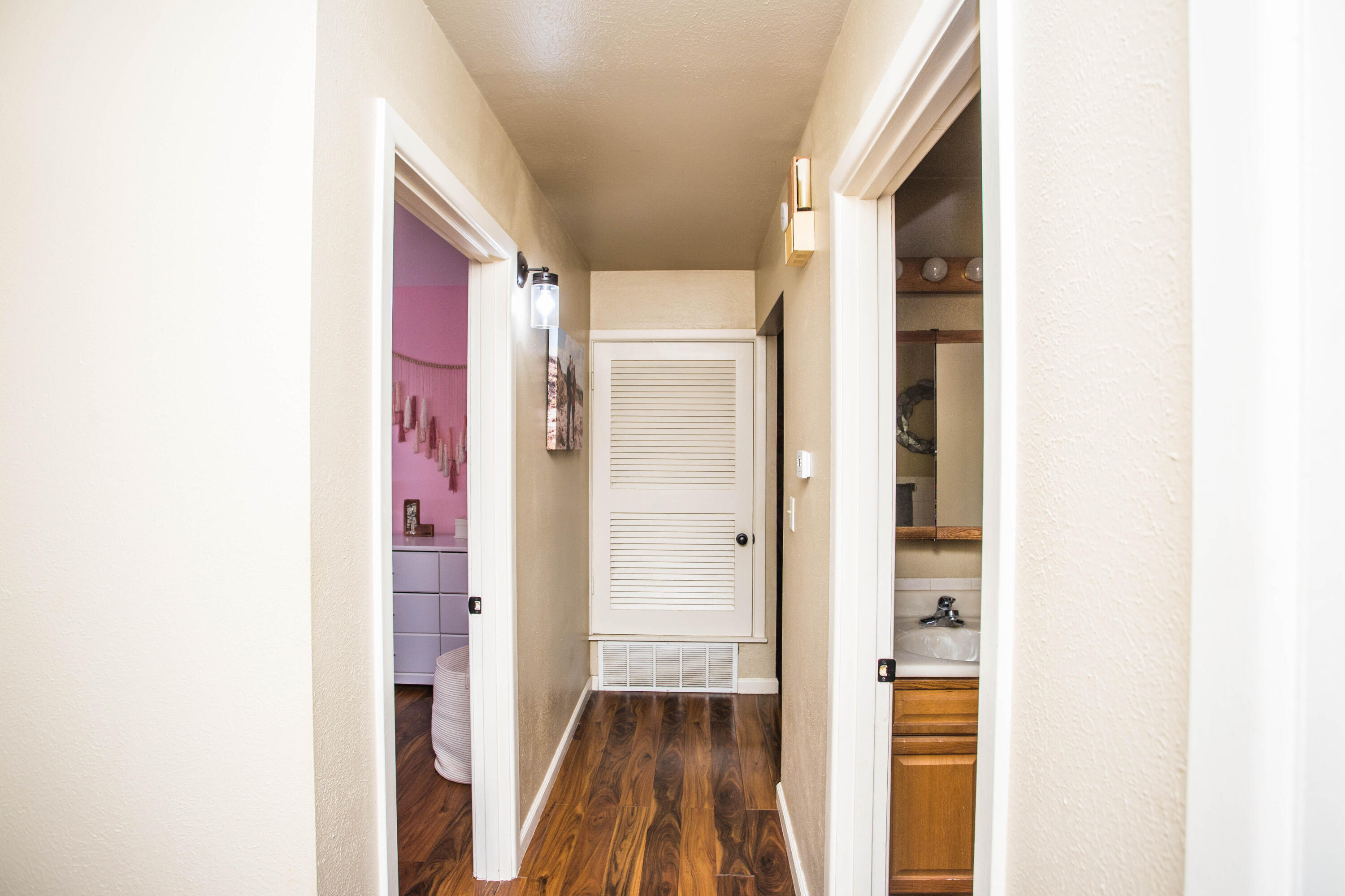 1550 West Lynn Street Slaton, TX 79364 - Photo 35 of 54 a view of a hallway with wooden floor and a bathroom