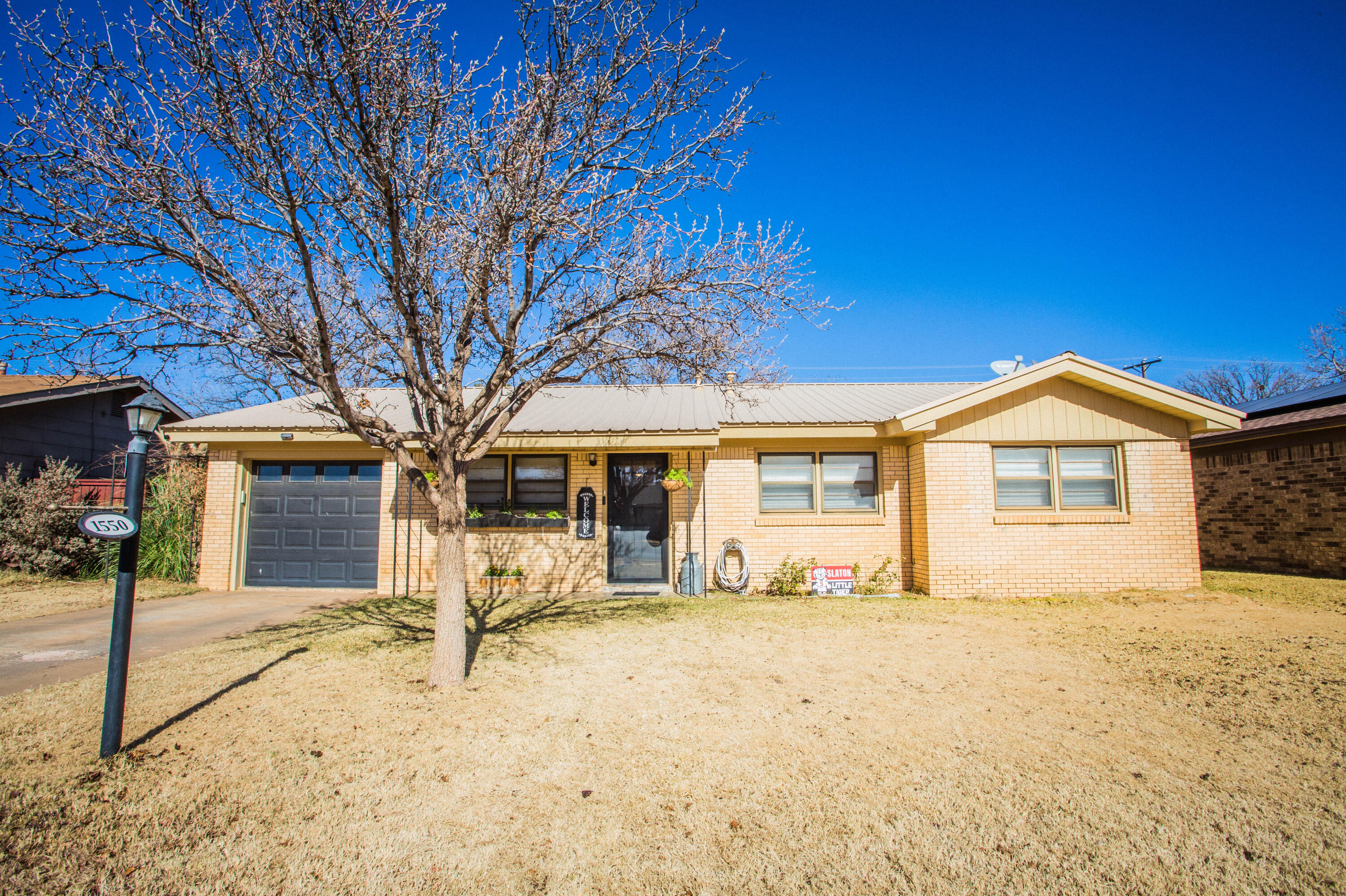 1550 West Lynn Street Slaton, TX 79364 - Photo 4 of 54 a front view of a house with a yard covered in snow