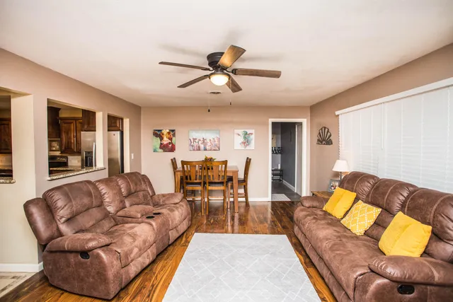 a living room with furniture and a wooden floor