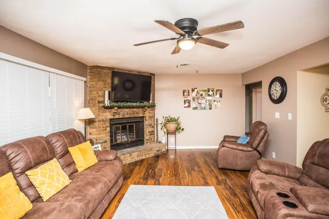 a living room with furniture a fireplace and a flat screen tv