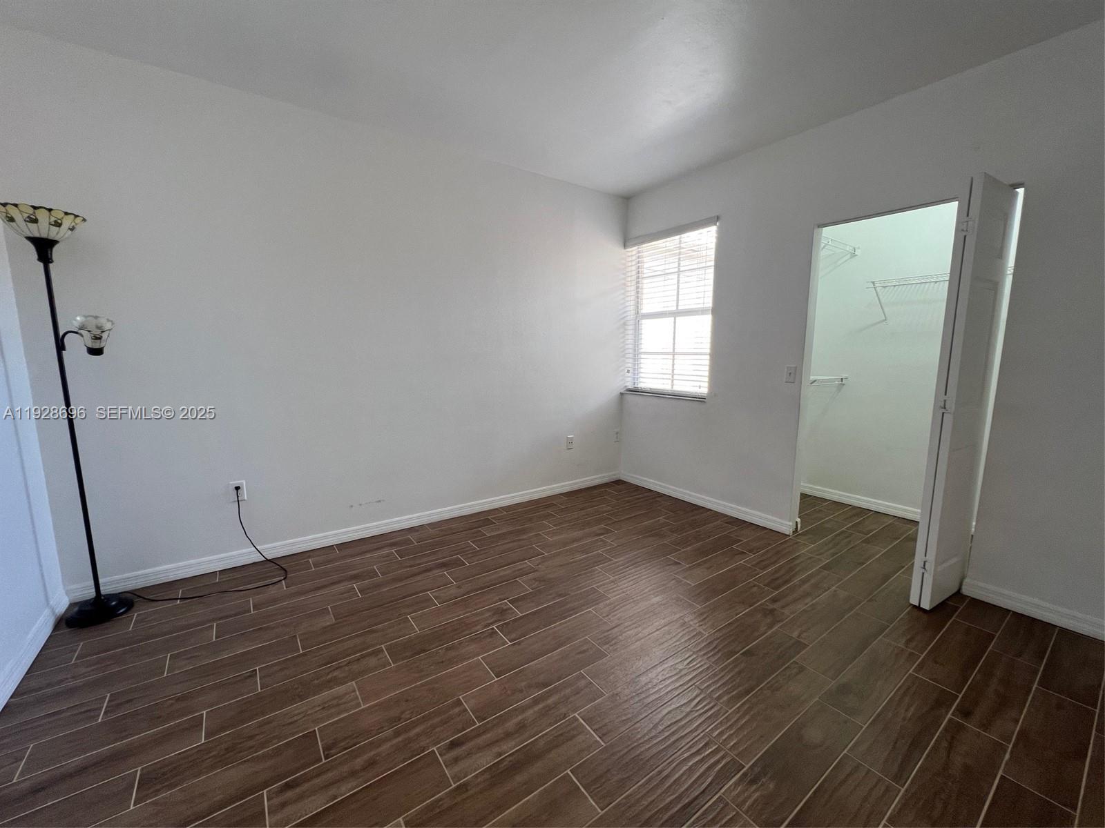 2406 Centergate Drive, Unit 201 Miramar, FL 33025 - Photo 16 of 41 an empty room with wooden floor and windows