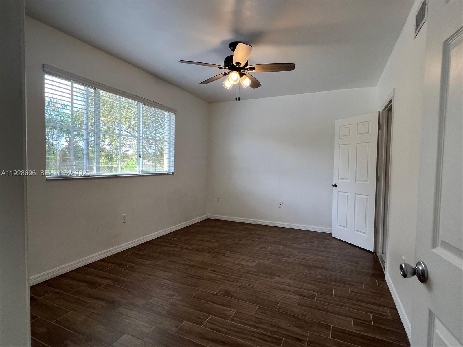 2406 Centergate Drive, Unit 201 Miramar, FL 33025 - Photo 20 of 41 a view of an empty room with wooden floor and a window