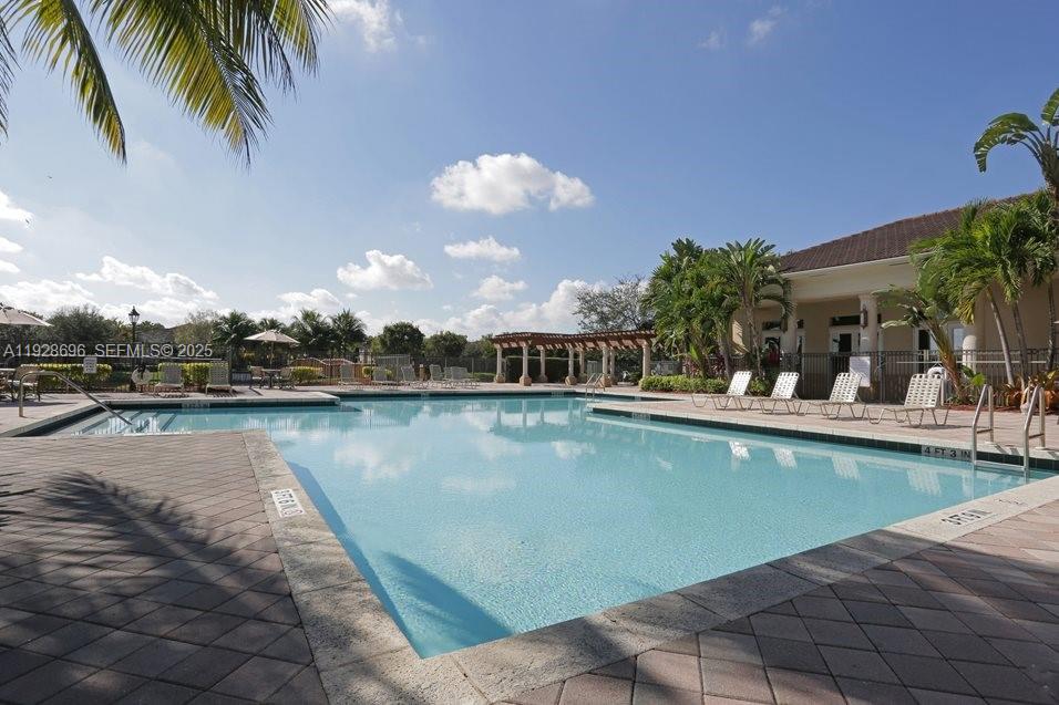 2406 Centergate Drive, Unit 201 Miramar, FL 33025 - Photo 34 of 41 a view of a swimming pool and lounge chair