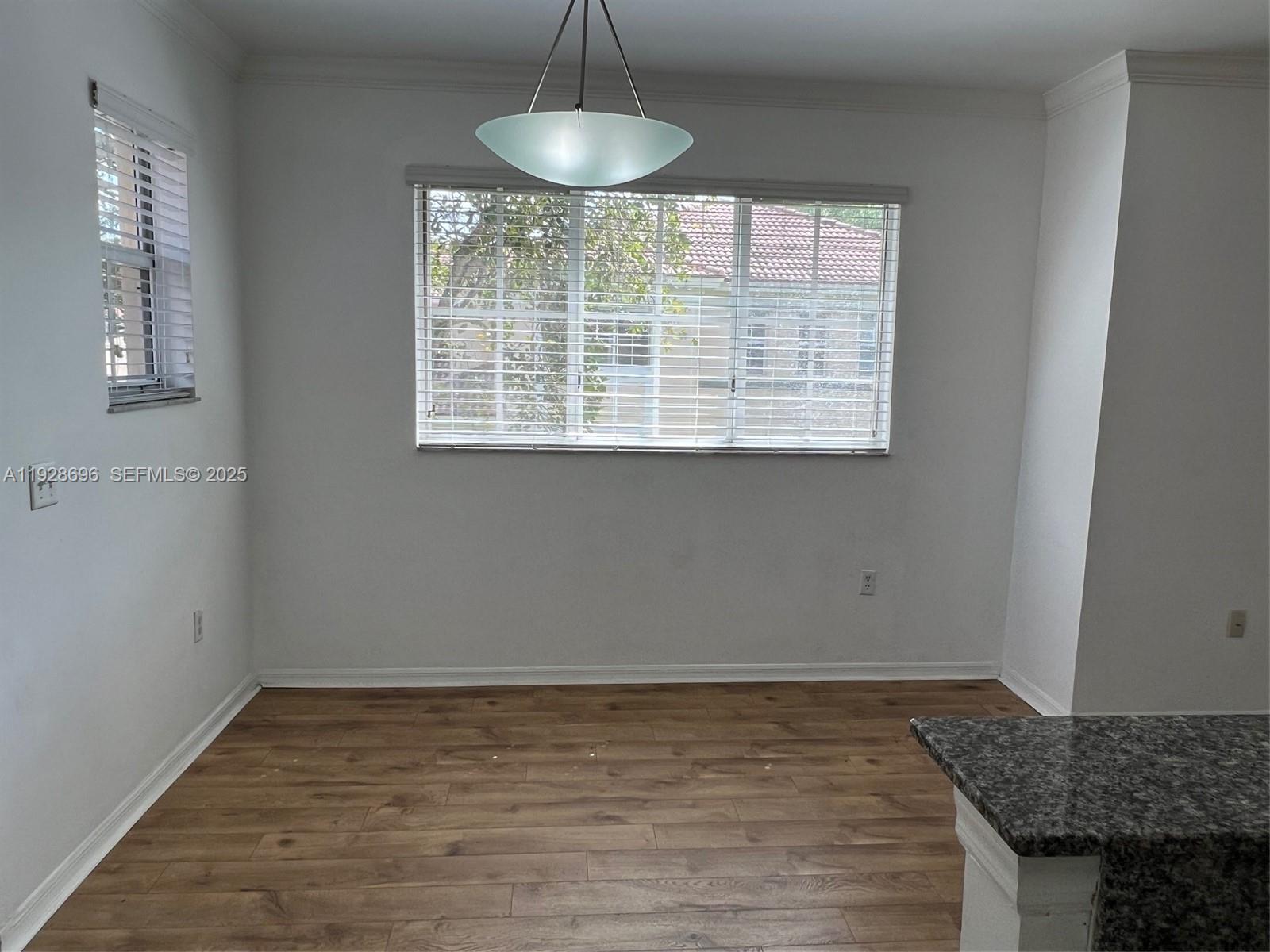 2406 Centergate Drive, Unit 201 Miramar, FL 33025 - Photo 5 of 41 a view of an empty room with wooden floor and a window
