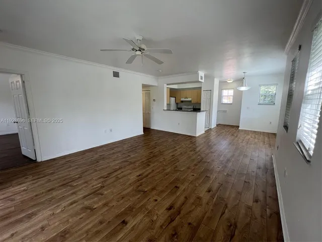 a view of a livingroom with wooden floor and a flat screen tv