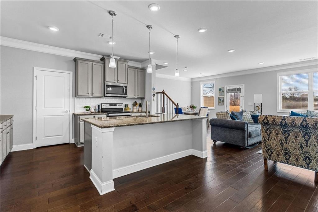 2787 Pearl Rdg Trace Buford, GA 30519 - Photo 21 of 52 a living room with kitchen island furniture and a wooden floor