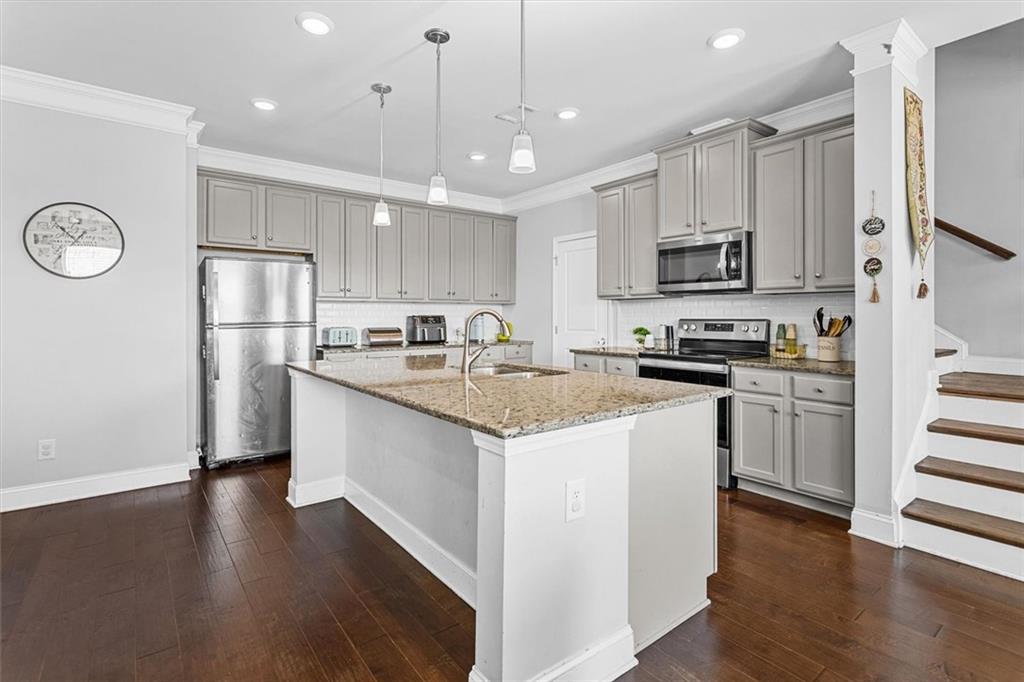 2787 Pearl Rdg Trace Buford, GA 30519 - Photo 22 of 52 a kitchen with kitchen island granite countertop appliances cabinets and a wooden floor
