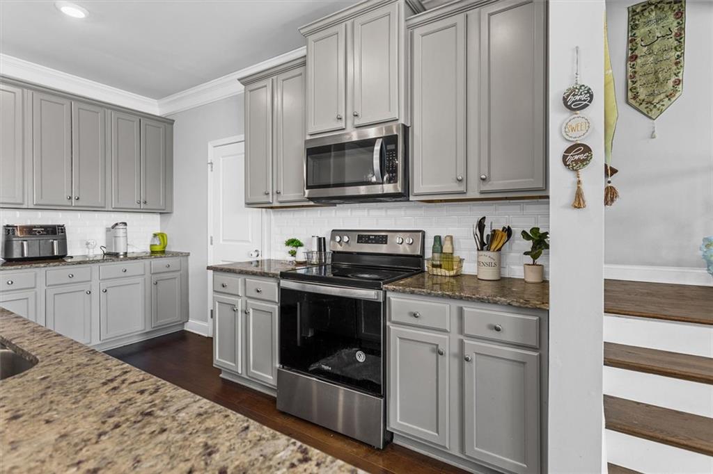 2787 Pearl Rdg Trace Buford, GA 30519 - Photo 25 of 52 a kitchen with stainless steel appliances granite countertop a stove a sink and a refrigerator