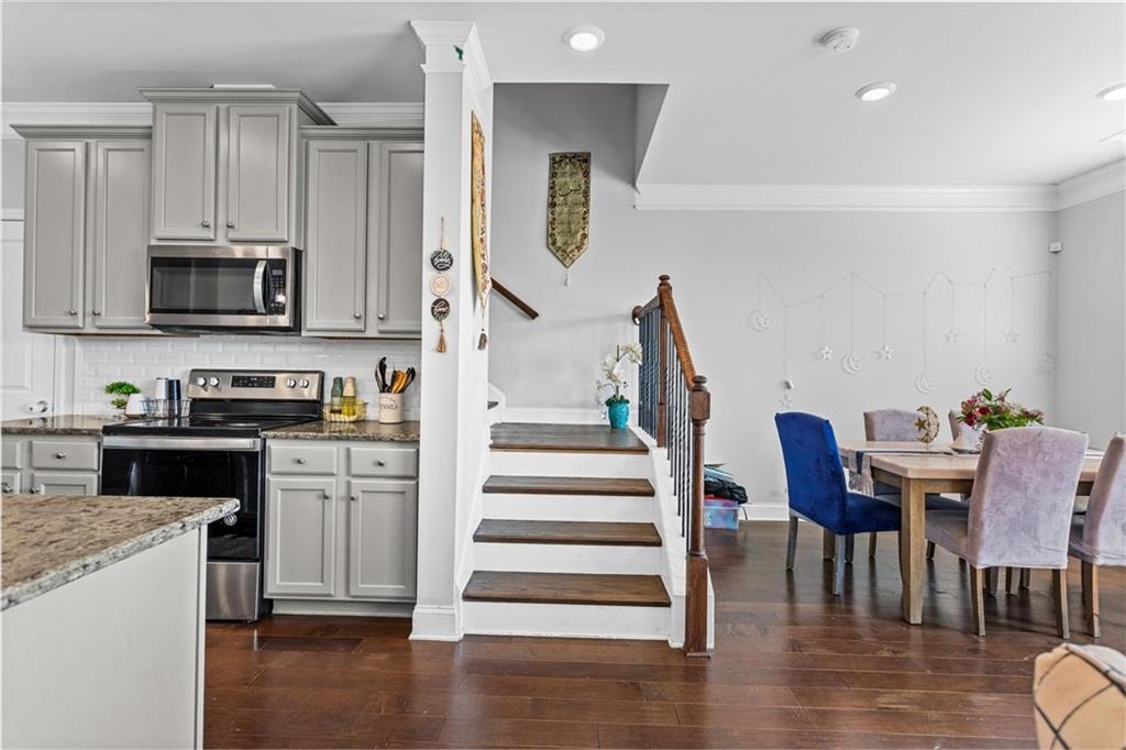 2787 Pearl Rdg Trace Buford, GA 30519 - Photo 36 of 52 a kitchen with granite countertop a stove a microwave and wooden floor