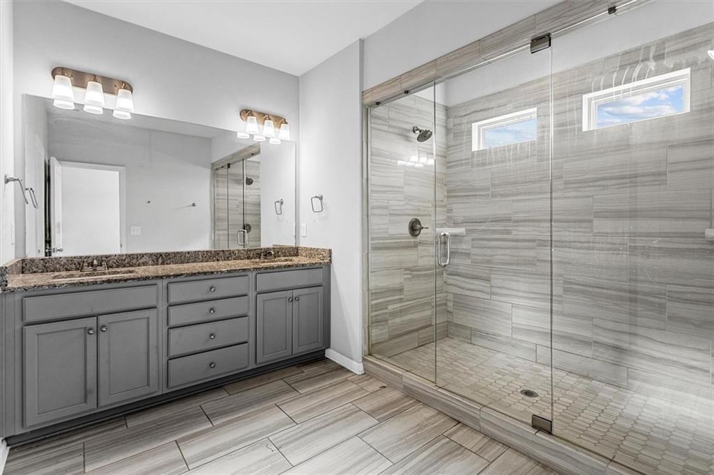 2787 Pearl Rdg Trace Buford, GA 30519 - Photo 43 of 52 a bathroom with a granite countertop sink mirror and shower