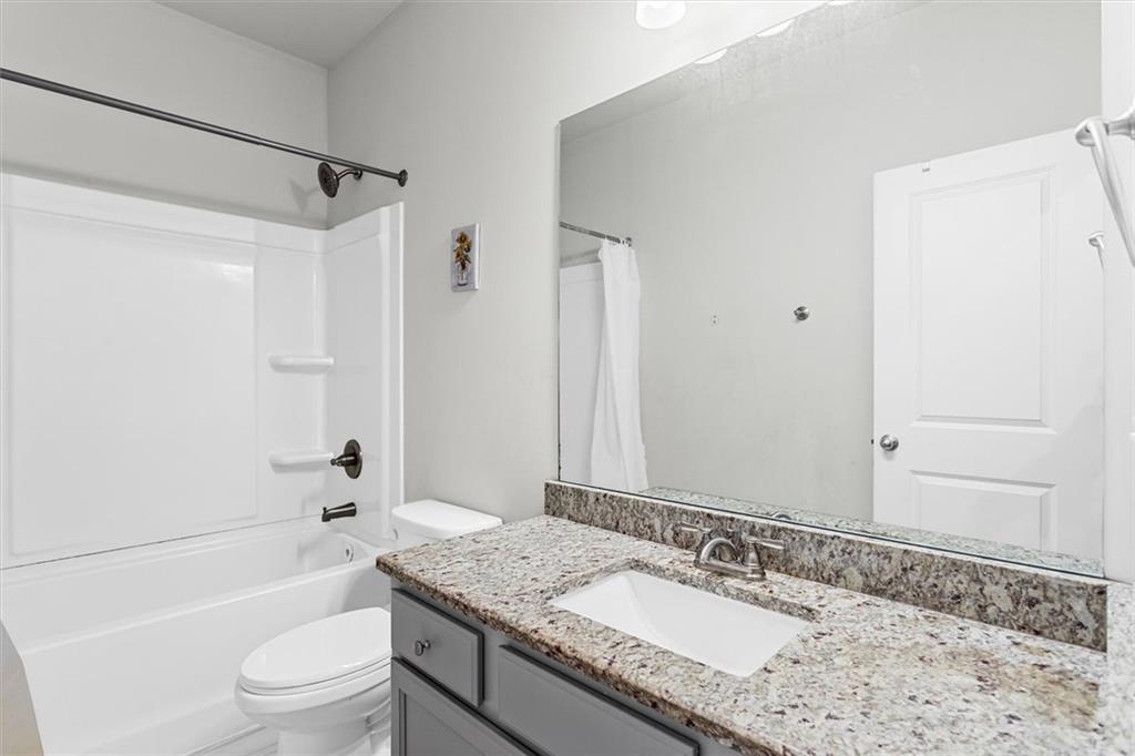 2787 Pearl Rdg Trace Buford, GA 30519 - Photo 46 of 52 a bathroom with a granite countertop sink toilet and shower