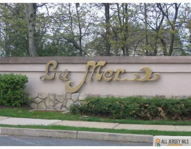 a view of a house with large windows and a tree