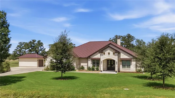 a front view of a house with a garden