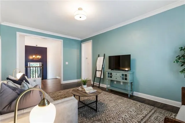 a view of a hallway with wooden floor and a bathroom