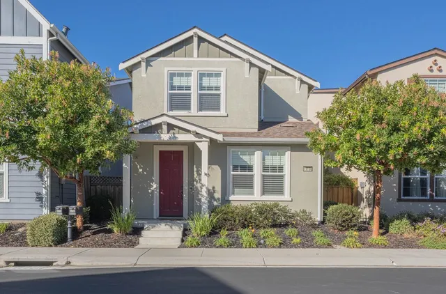 a front view of a house with a yard and potted plants