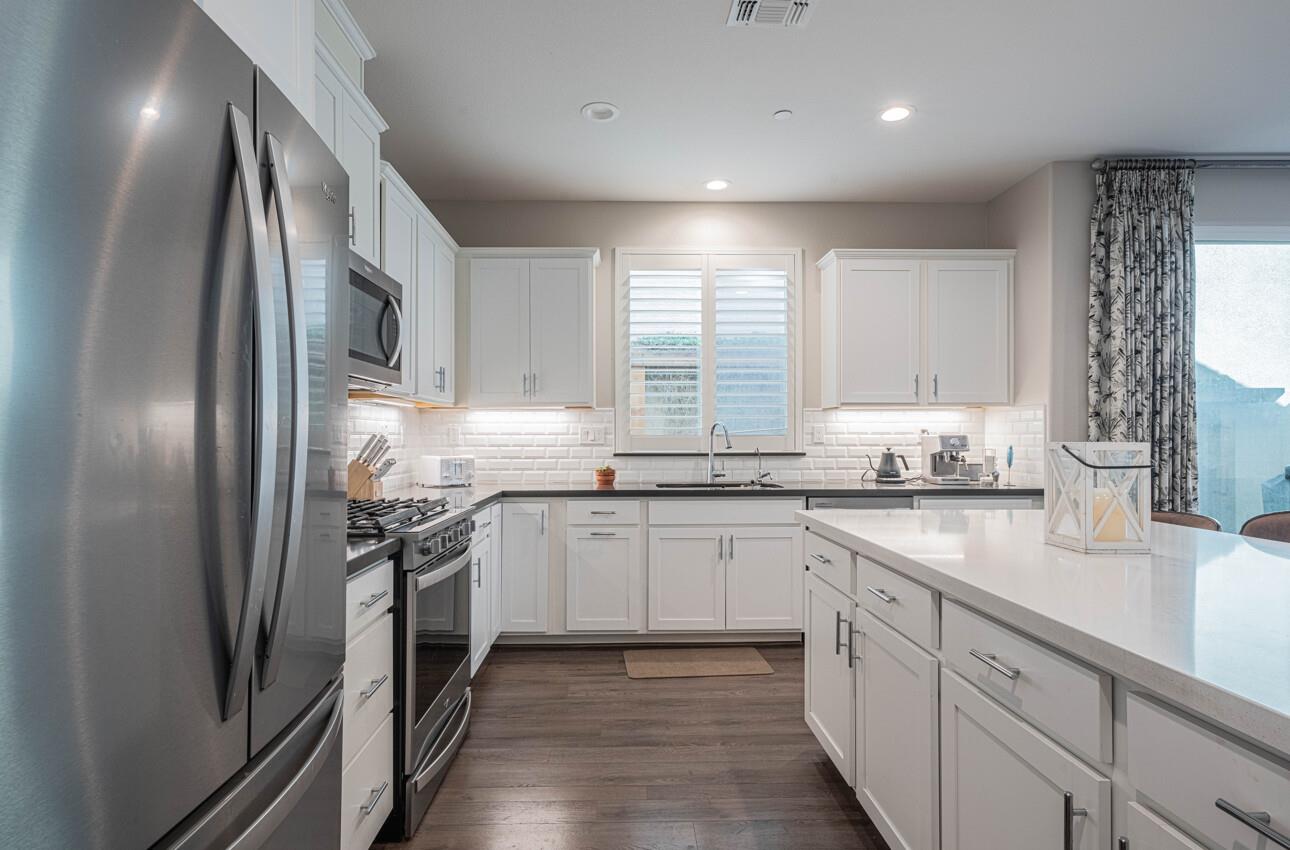 19130 Fallingwater Lane Marina, CA 93933 - Photo 12 of 43 a kitchen with stainless steel appliances granite countertop a sink a stove a refrigerator and cabinets