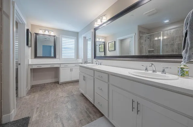 a spacious bathroom with double sink and a mirror