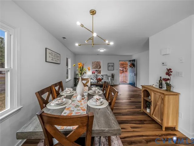 a view of a dining room with furniture wooden floor and chandelier