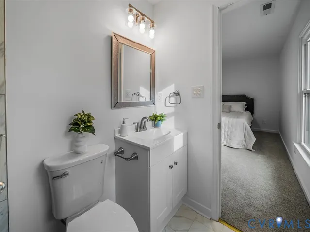 a bathroom with a toilet sink and mirror