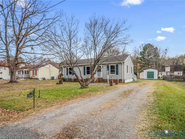 a view of a house with a yard and large trees