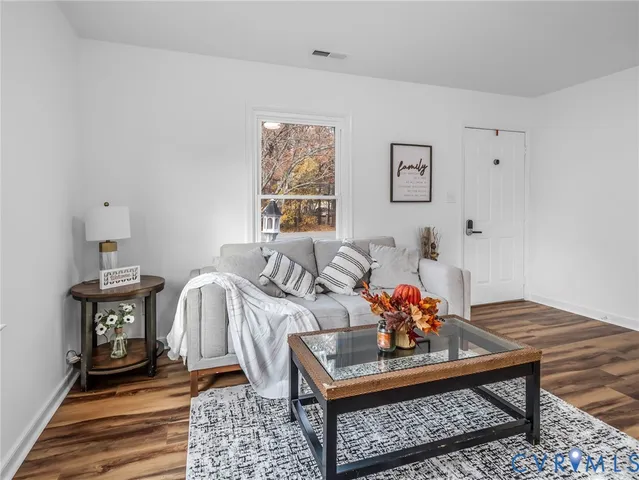 a living room with furniture and wooden floor