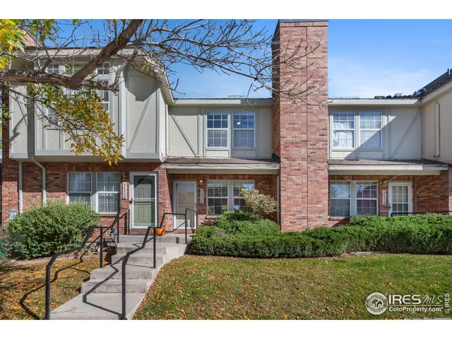 a view of a house with a chairs and table in a patio