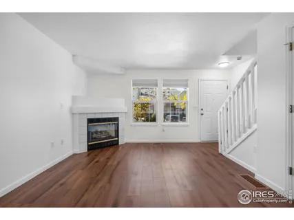 a view of an empty room with a fireplace and a window