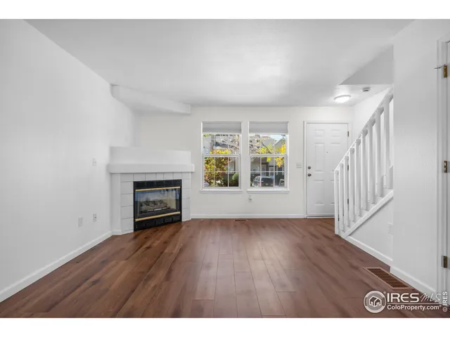 a view of an empty room with a fireplace and a window