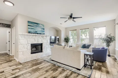 a living room with furniture a fireplace and a potted plant