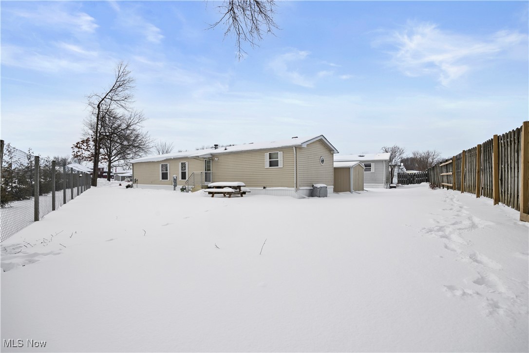 35157 Center Ridge Road, Unit 151 North Ridgeville, OH 44039 - Photo 26 of 29 Snow covered back of property featuring a fenced backyard and a storage shed