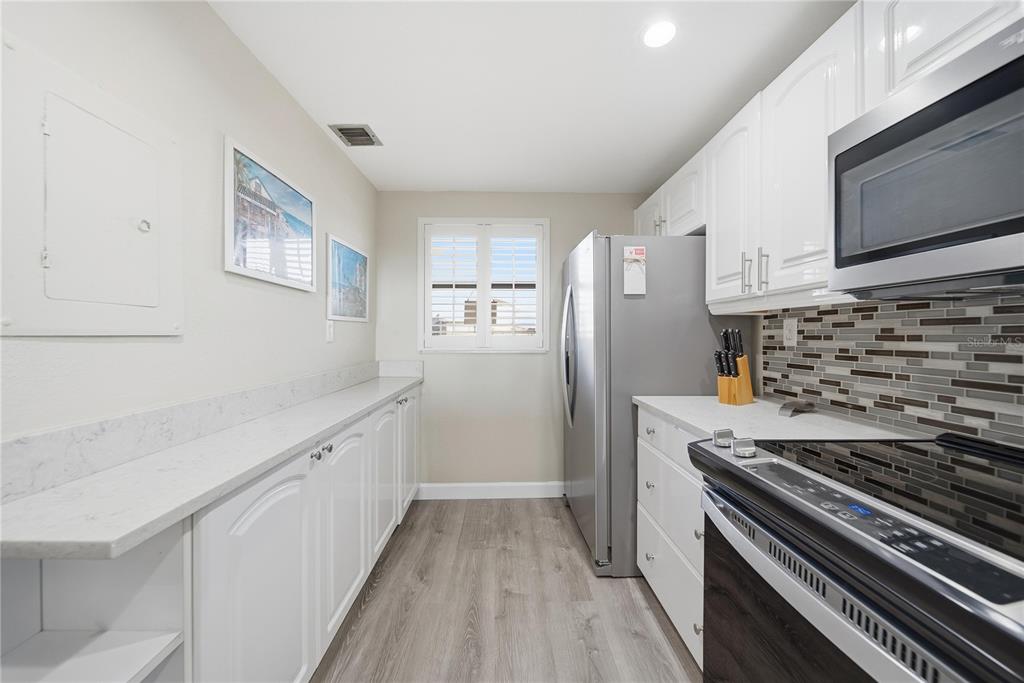 17580 Gulf Boulevard, Unit 302 Redington Shores, FL 33708 - Photo 15 of 37 a kitchen with granite countertop a stove and a refrigerator