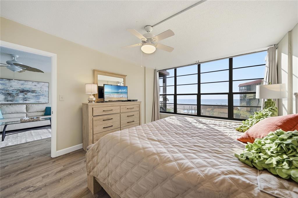 17580 Gulf Boulevard, Unit 302 Redington Shores, FL 33708 - Photo 16 of 37 a bedroom with a bed and a dresser with wooden floor