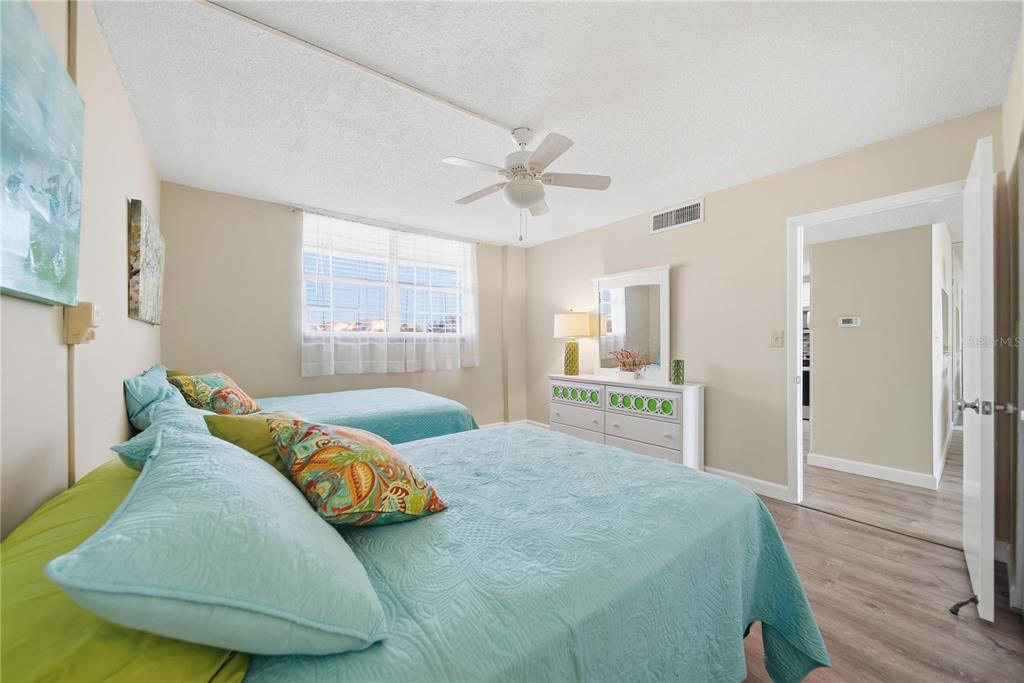 17580 Gulf Boulevard, Unit 302 Redington Shores, FL 33708 - Photo 21 of 37 a bedroom with a bed and a chandelier