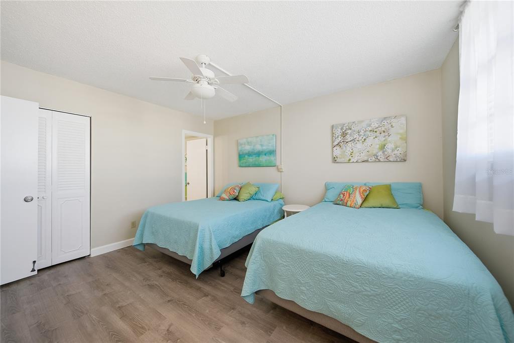17580 Gulf Boulevard, Unit 302 Redington Shores, FL 33708 - Photo 22 of 37 a bedroom with two beds and painting on the wall