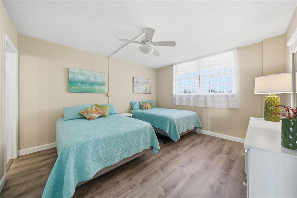 17580 Gulf Boulevard, Unit 302 Redington Shores, FL 33708 - Photo 23 of 37 a bedroom with two beds and painting on the wall