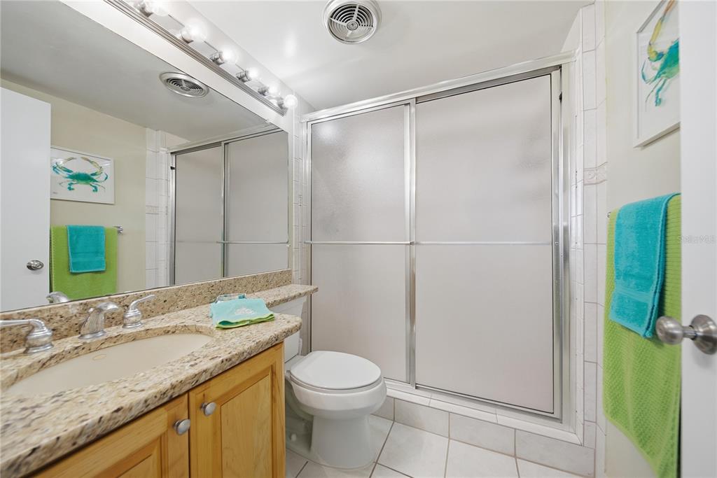 17580 Gulf Boulevard, Unit 302 Redington Shores, FL 33708 - Photo 24 of 37 a bathroom with a granite countertop sink toilet and shower