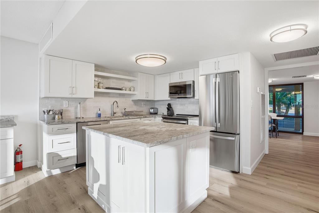 17580 Gulf Boulevard, Unit 302 Redington Shores, FL 33708 - Photo 33 of 37 a kitchen with stainless steel appliances granite countertop a refrigerator stove and sink