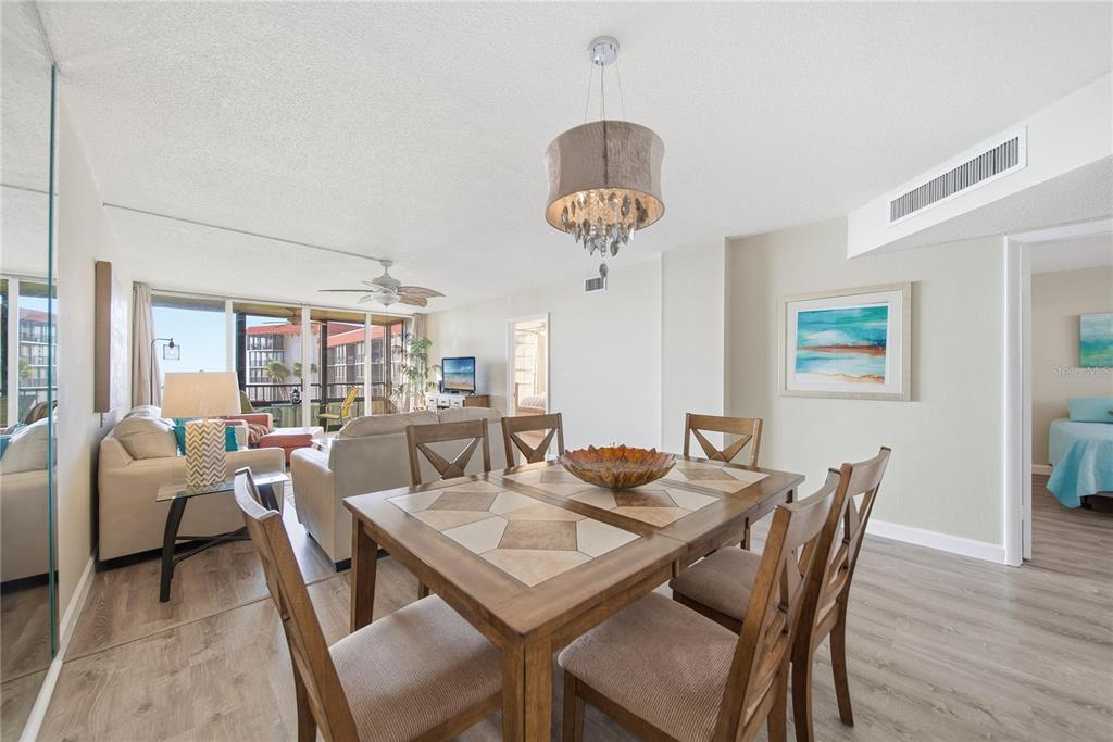 17580 Gulf Boulevard, Unit 302 Redington Shores, FL 33708 - Photo 7 of 37 a view of a dining room with furniture wooden floor and chandelier