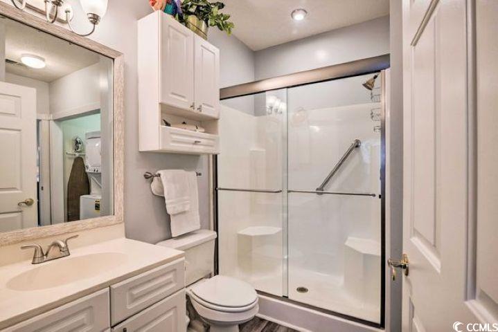 4864 Carnation Circle, Unit 204 Myrtle Beach, SC 29577 - Photo 11 of 13 Bathroom with vanity, a shower stall, and dark wood-type flooring