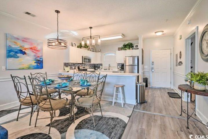 4864 Carnation Circle, Unit 204 Myrtle Beach, SC 29577 - Photo 2 of 13 Dining area with light wood finished floors and crown molding