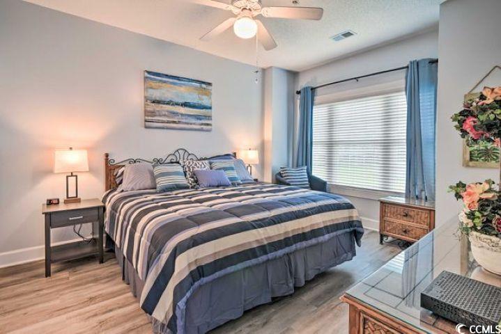 4864 Carnation Circle, Unit 204 Myrtle Beach, SC 29577 - Photo 7 of 13 Bedroom featuring light wood-style floors and a ceiling fan