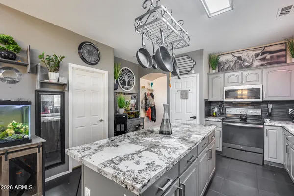 a kitchen with stainless steel appliances granite countertop a sink dishwasher stove and oven