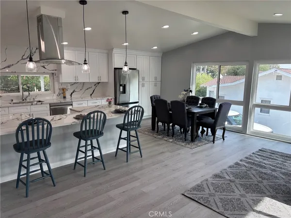 a view of a a dining room with furniture window and wooden floor