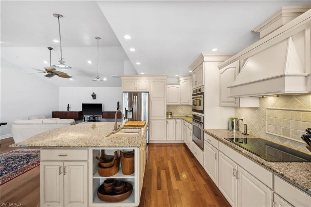 1986 Imperial Golf Course Boulevard Naples, FL 34110 - Photo 12 of 38 a kitchen with stainless steel appliances granite countertop a sink a stove and a wooden floors