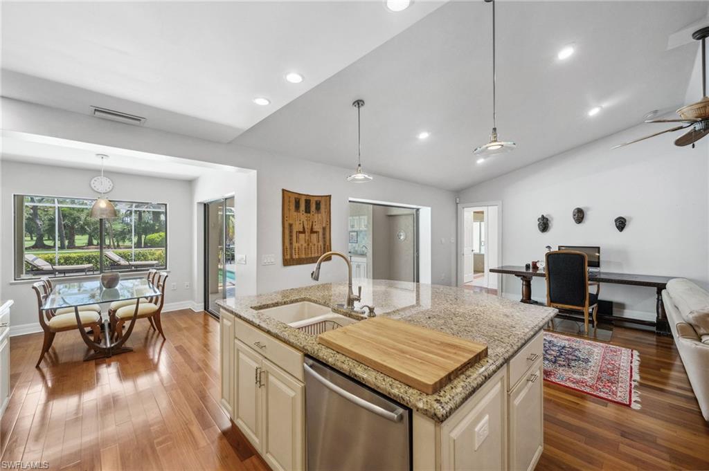 1986 Imperial Golf Course Boulevard Naples, FL 34110 - Photo 13 of 38 a kitchen with a table chairs stove and wooden floor