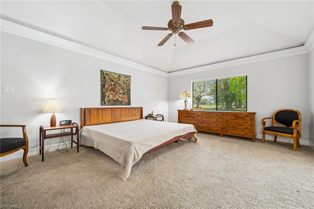 1986 Imperial Golf Course Boulevard Naples, FL 34110 - Photo 16 of 38 a bedroom with a bed a couch and a chandelier